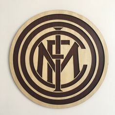 a circular wooden sign with the letters n and f in it's center, on a white wall