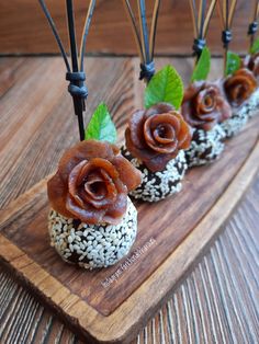 some food is sitting on top of a wooden board with green leaves and sprinkles