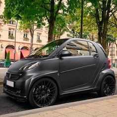 a smart car is parked on the side of the street