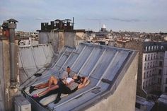 two people laying on the roof of a building