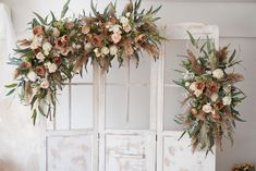 two white doors decorated with flowers and greenery