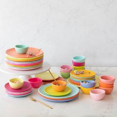 a table topped with plates and bowls next to a cake on top of a plate