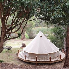 a large white tent in the middle of some trees