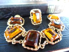 This is a beautiful vintage Sarah Coventry jewelry set. The set includes a cocktail ring and matching bracelet, with large glass faux topaz faceted stones. I believe the metal is gold plate it is not magnetic. As is, the ring is 8 and can be adjusted slightly. The bracelet is 7 3/4 in. long with a fold over clasp. It is in great condition. Thank you for looking! Vintage Multi-stone Jewelry For Ceremonial Occasion, Ornate Multi-stone Collectible Jewelry, Vintage Bronze Multi-strand Jewelry, Vintage Gold-tone Metal Charm Bracelet, Designer Costume Jewelry, Sarah Coventry Jewelry, Vintage Amber Hand-strung Beads, Gems, And Cabochons, Sarah Coventry, Coventry