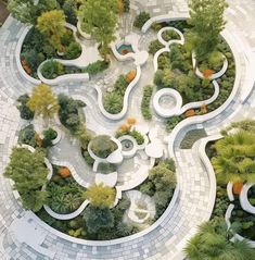 an aerial view of a circular garden with trees and plants in the center, surrounded by white tiles