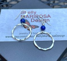 Hammered silver hoop earrings with lapis lazuli gemstones. These hammered silver hoop earrings are very lightweight and lovely! You will hardly know that you're wearing them except for all the compliments you'll be getting! The silver hoops have a hammered texture and an antique finish. The small round gemstones are lapis lazuli. The French ear wires are sterling silver. These earrings are 2 inches long and 1 inch wide. As I mentioned, they are very lightweight! Only 2 grams. All my jewelry come Blue Sterling Silver Wire Wrapped Hoop Earrings, Blue Wire Wrapped Sterling Silver Hoop Earrings, Blue Hoop Earrings In Sterling Silver, Blue Hoop Sterling Silver Jewelry, Blue Sterling Silver Hoop Earrings Nickel-free, Blue Sterling Silver Hoop Earrings Nickel Free, Nickel Free Silver Lapis Lazuli Jewelry, Blue Sterling Silver Hoop Jewelry, Silver Lapis Lazuli Drop Earrings