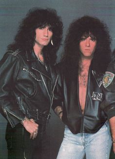 two men in leather jackets standing next to each other