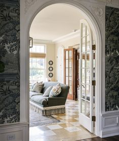 a living room with an archway leading to another room