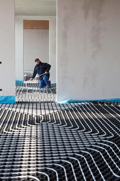 a man is working on the floor in an empty room