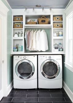 a washer and dryer in a laundry room with shelves on the wall above them