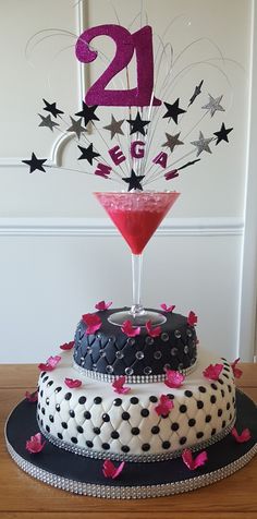 two tiered cake decorated with pink and black frosting, stars and confetti