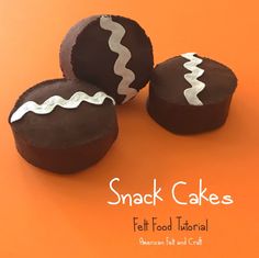 three chocolate covered desserts with white icing on an orange background that says snack cakes