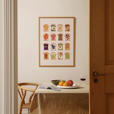 a bowl of fruit sits on a table in front of a framed art piece that is hanging above the dining room table