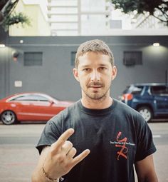 a man standing in the middle of a parking lot holding his hand out to someone