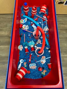 a red and blue table topped with an ice cream sundae covered in cat in the hat decorations