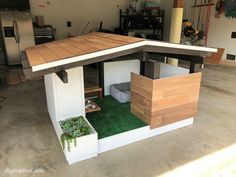 a dog house built into the side of a garage with plants growing out of it