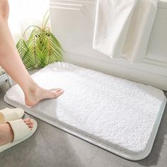 a person standing on a bath mat with their feet propped up against the edge of it