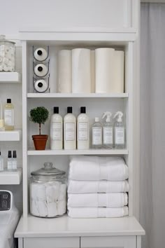 a white shelf filled with lots of bottles and towels