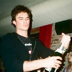 a young man holding a wine bottle in his hand