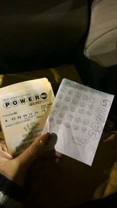 a person holding two tickets in their hand