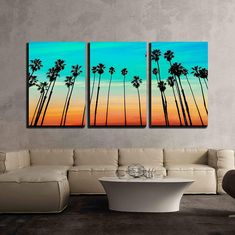 three paintings on the wall of a living room