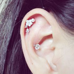 a close up of a person's ear with three flowers on the middle one