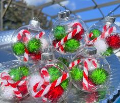 christmas ornaments are sitting on top of a glass platter with candy canes in them