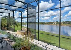 an enclosed patio with tables and chairs overlooking the water's edge is pictured in this image