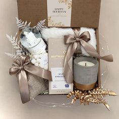 a gift box filled with candles, blankets and other holiday items for someone's special occasion