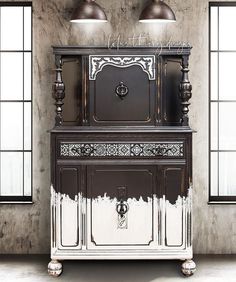 an old fashioned cabinet with two lights on top