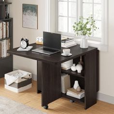 a laptop computer sitting on top of a wooden desk next to a book shelf filled with books