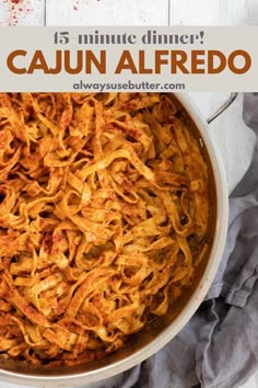 a large pot filled with pasta on top of a wooden table next to a knife and fork