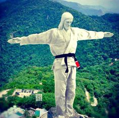 a statue of jesus on top of a mountain with his arms spread out and hands outstretched