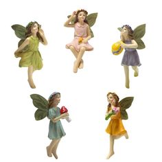 four little fairy figurines sitting on top of each other, one holding a flower