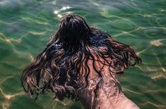 a woman with wet hair standing in the water