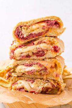 three sandwiches stacked on top of each other with cheese and meat in the middle,