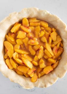 a pie crust filled with sliced peaches and caramel sauce