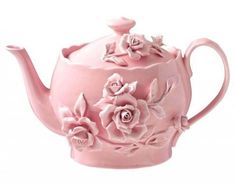 a pink tea pot with flowers on it