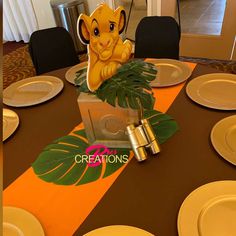 the lion cub centerpiece is sitting on top of a table with plates and napkins