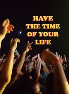 many people are holding their hands up in front of a sign that says have the time of your life