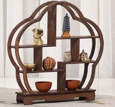 a wooden shelf with bowls and figurines on it