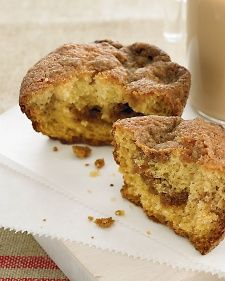 two muffins sitting on top of a napkin next to a glass of milk