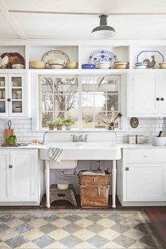 a kitchen with lots of white cabinets and counters