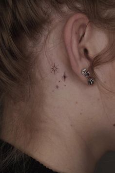 a woman's ear with small stars on it