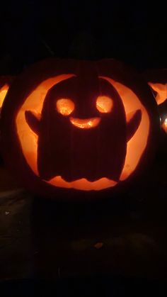 pumpkins with faces carved into them in the dark