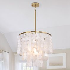 a chandelier hanging from the ceiling in a room with white walls and windows