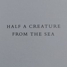 a white wall with the words half a creature from the sea written in black ink