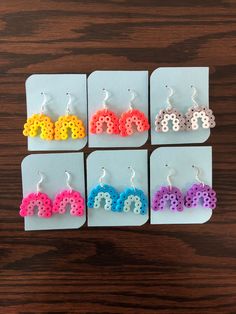 four pairs of earrings with the word love spelled out in different colors and shapes on them