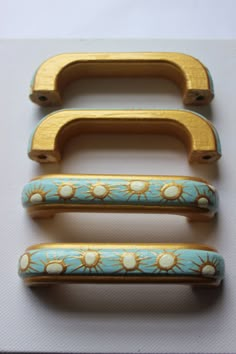 three wooden handles with flowers painted on them