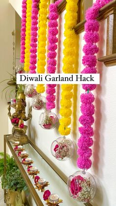 colorful garlands are hanging on the wall next to vases with flowers in them